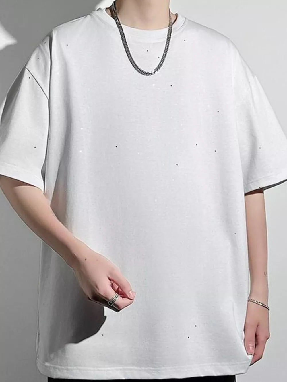 White oversized cotton t-shirt with distressed details and a crew neck.