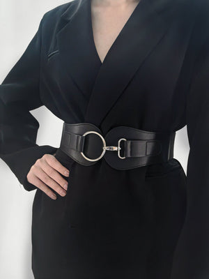 Black leather cincher belt with a sculpted silver buckle and ring detail.