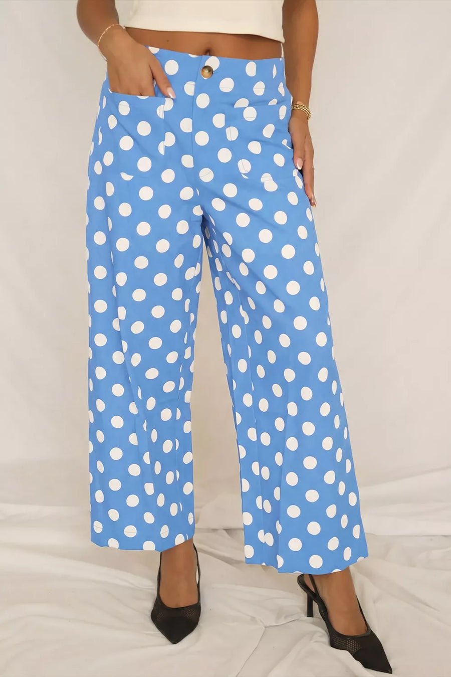 Blue polka dot cropped pants with pockets and a button closure.