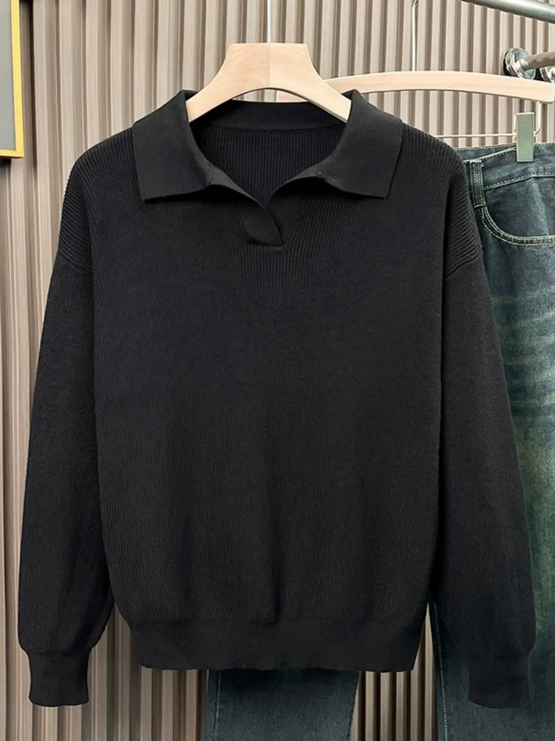 Black collared knit sweater with ribbed texture and a relaxed fit.