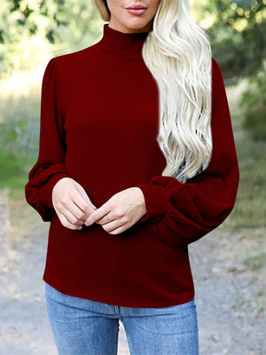 Burgundy mock neck top with puff sleeves and button back detail.