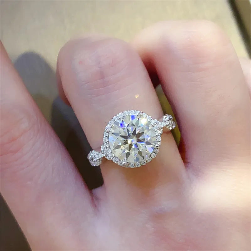 Silver halo moissanite ring with twisted band and round center stone.