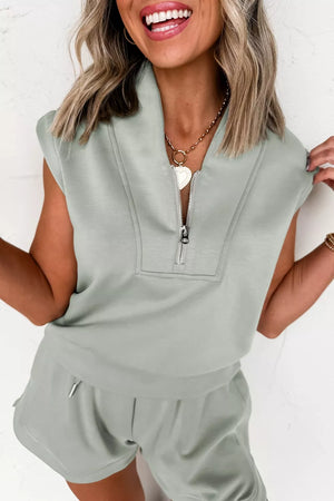 Sleek quarter-zip sleeveless top and shorts set in light green with banded hem.