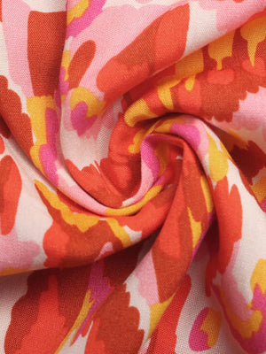 Abstract print V-neck maxi dress in colorful floral pattern with pink, orange, and yellow hues.