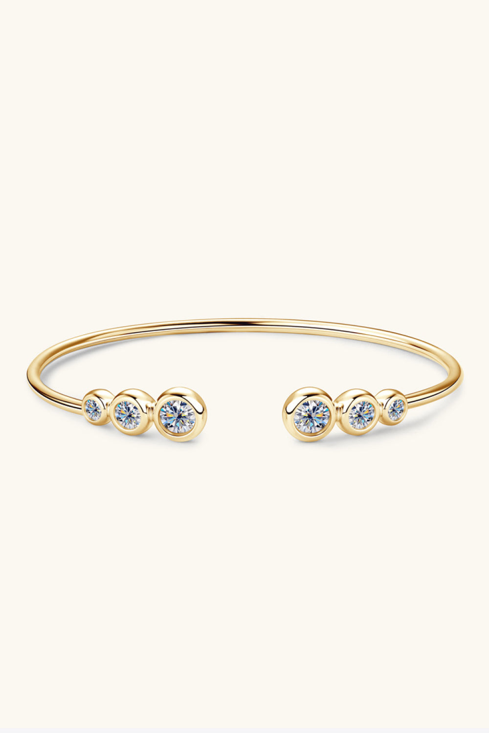 Gold open-ended cuff bracelet with five bezel-set moissanite stones.