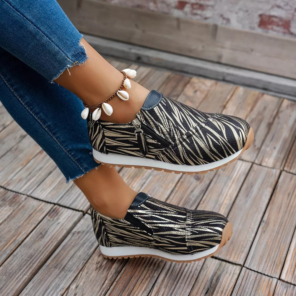 Zebra print slip-on flats with side zipper detail and comfortable sole.