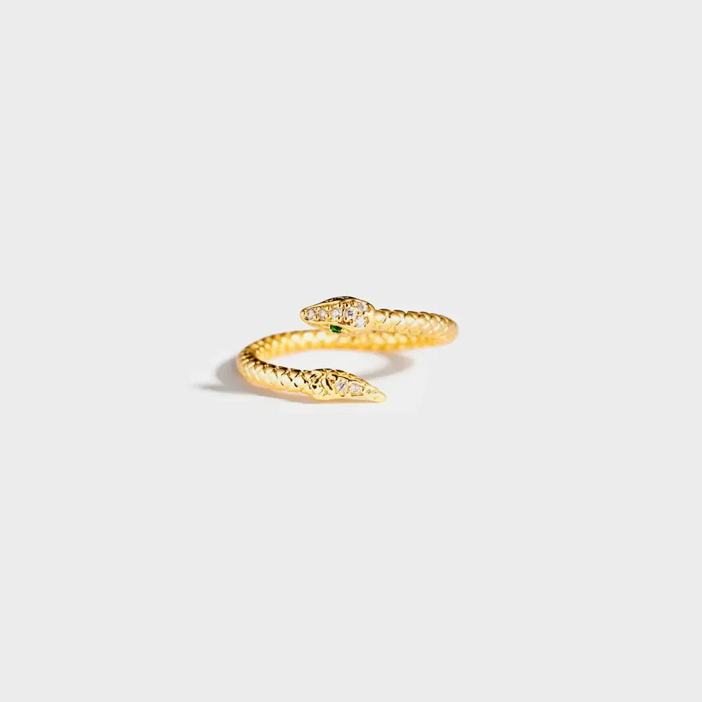 Gold snake ring with diamond accents and green eye detail