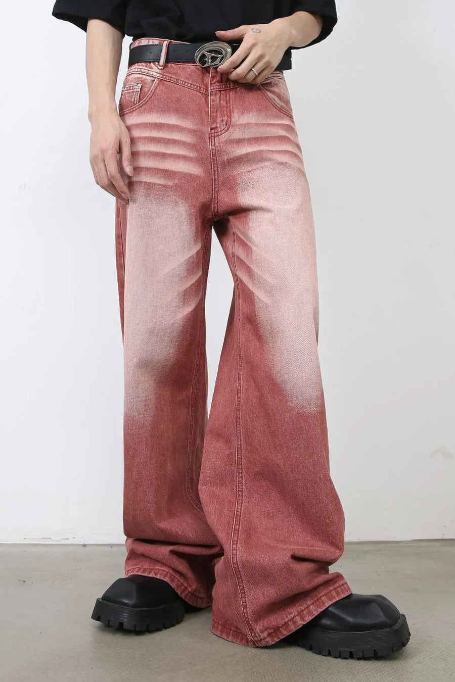 Dip-dye wide-leg denim trousers in rust with a faded effect, styled with chunky black shoes.
