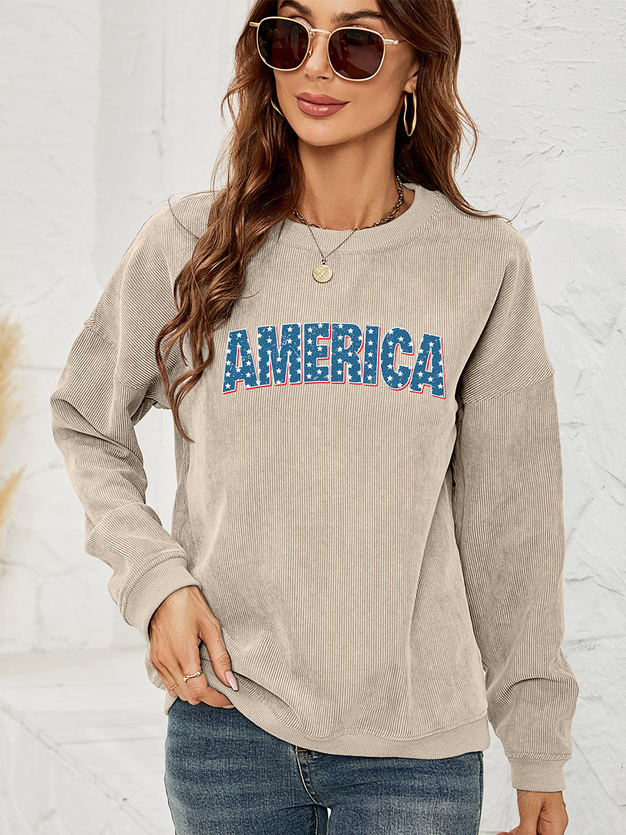 Sand corduroy sweatshirt with "AMERICA" graphic in red, white, and blue stars and stripes.