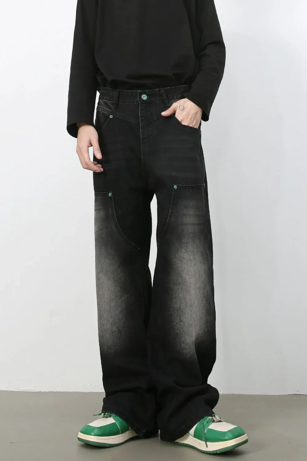 Faded wash wide-leg carpenter jeans in dark black with green button detail.