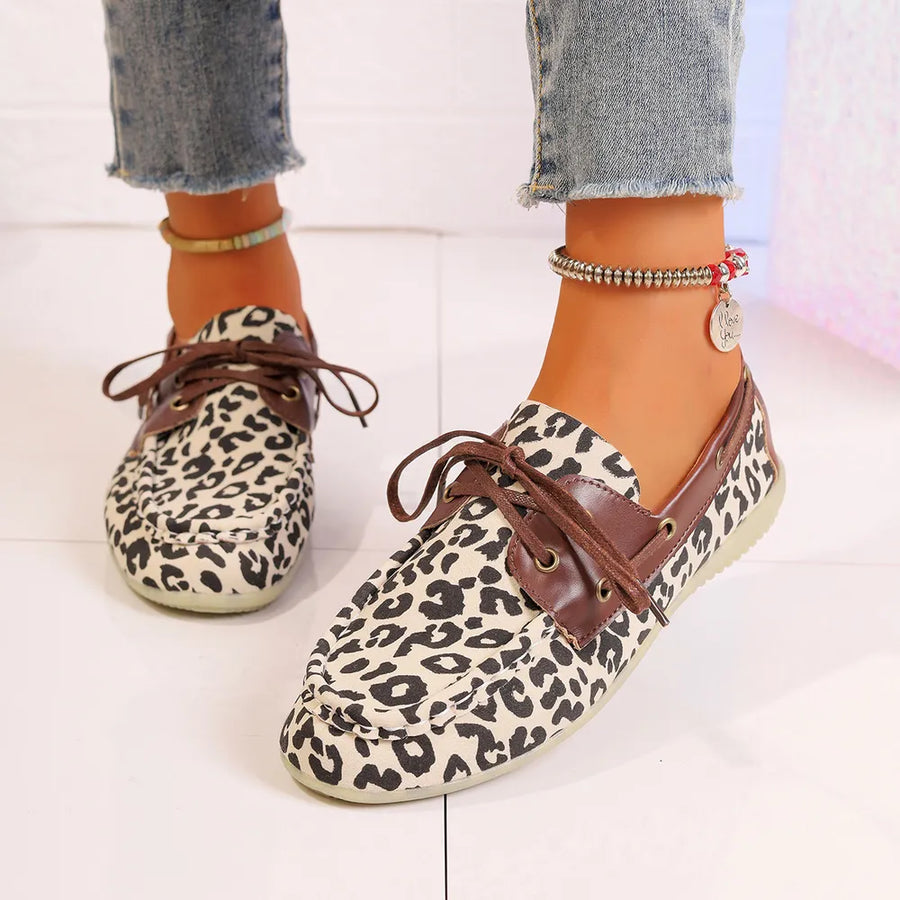 Leopard print boat shoes with leather trim and lace-up detail.