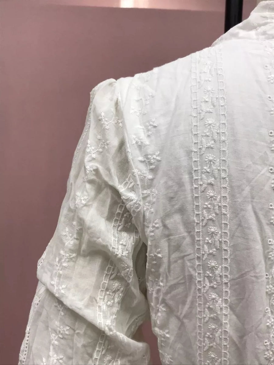 White cotton blouse with floral embroidery and textured details