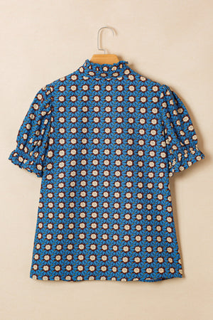 Blue cotton blouse with floral print, ruffled mock neck, and puff sleeves.