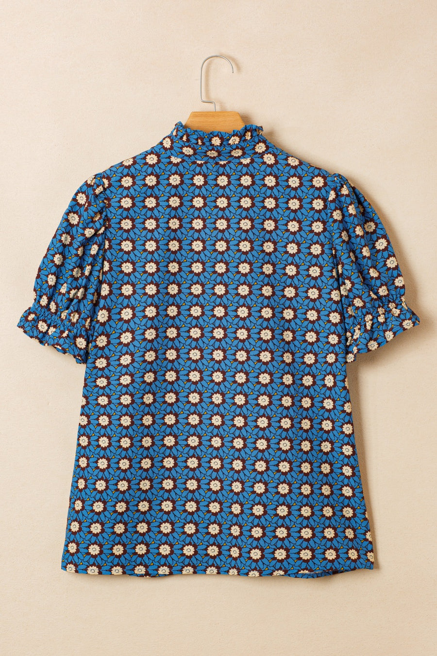 Blue cotton blouse with floral print, ruffled mock neck, and puff sleeves.