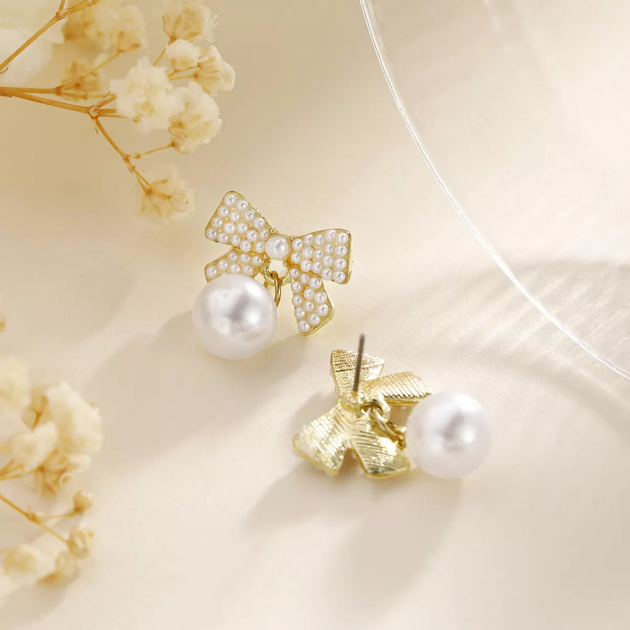 Gold bowknot pearl drop earrings with 18K gold plating.