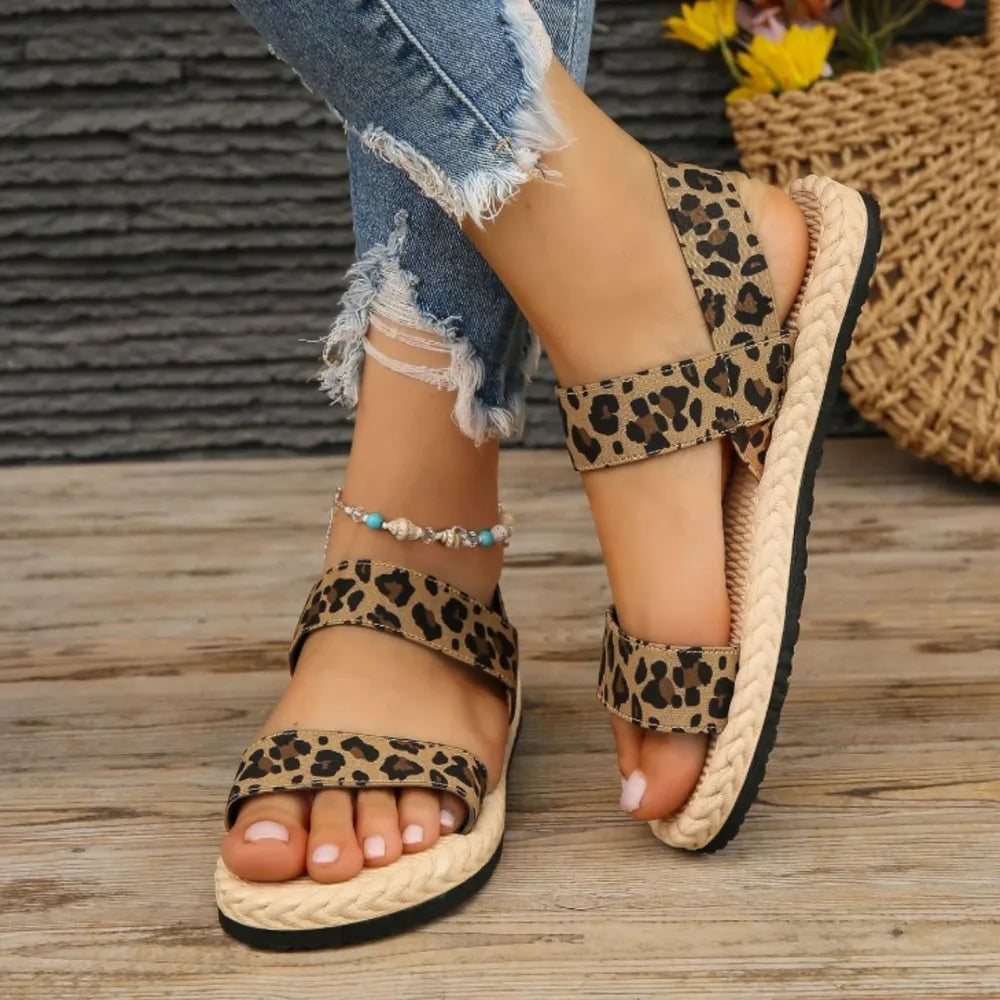 Leopard print cross-strap sandals with rope sole and adjustable straps.