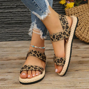 Leopard print cross-strap sandals with rope sole and adjustable straps.