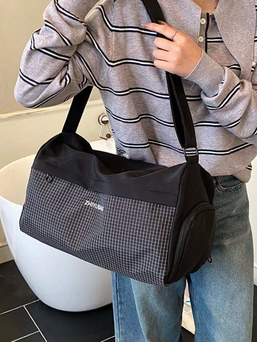 Black travel organizer bag with a subtle grid pattern and white text detail.