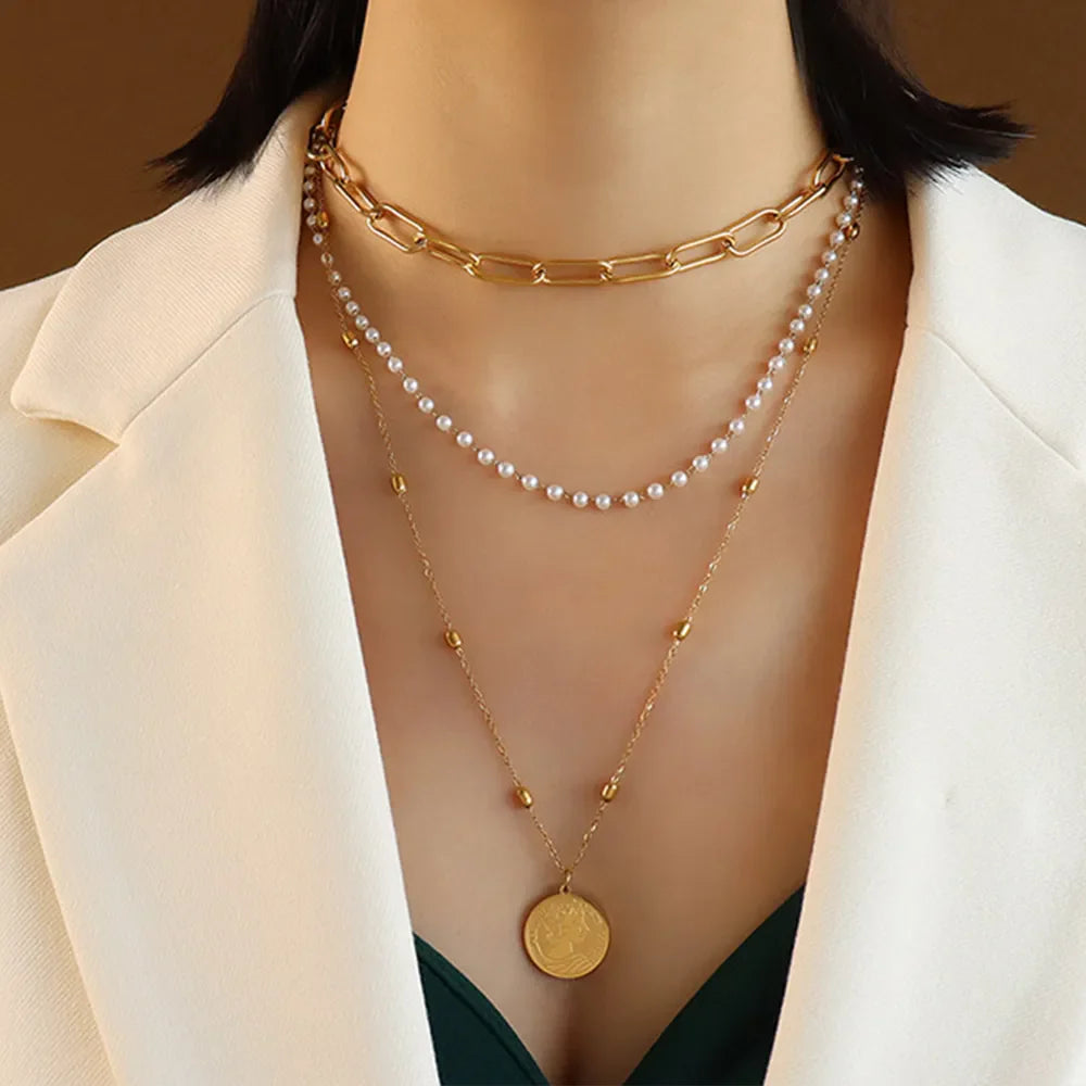 Gold layered necklace with chain, pearls, and coin pendant