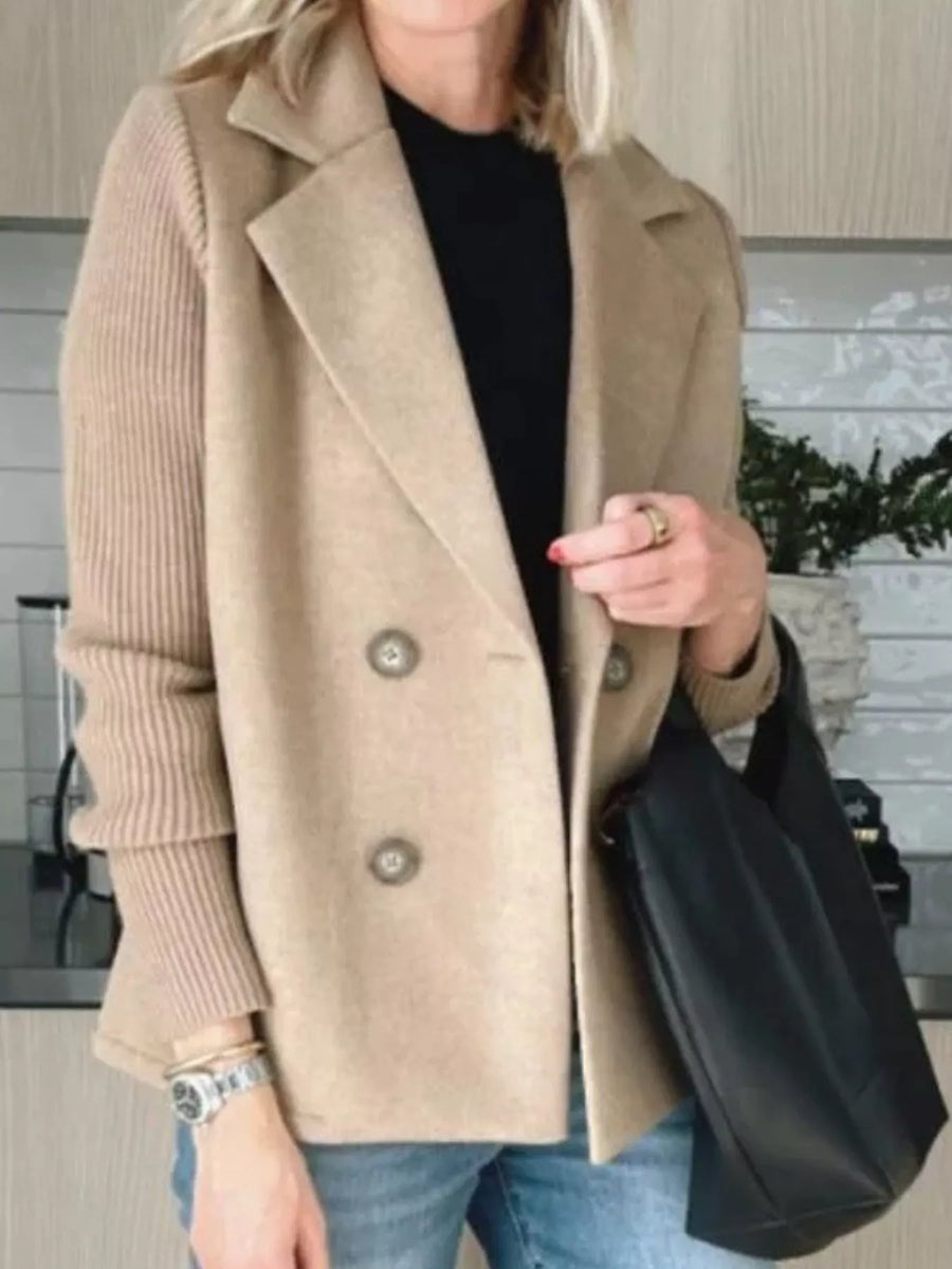 Tan double-breasted knit sleeve outerwear coat with button details and a notched lapel.