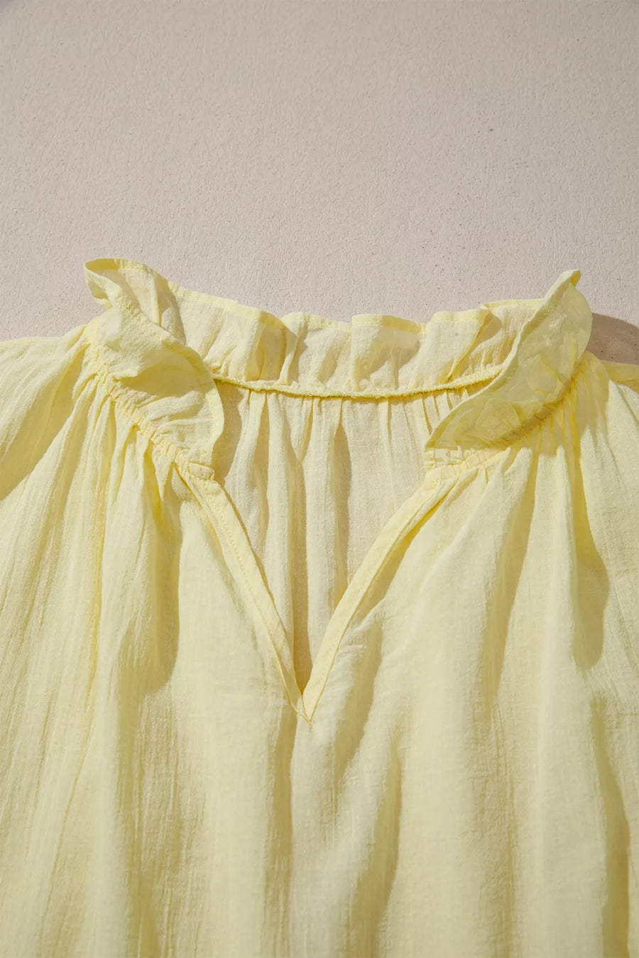 Yellow cotton blend shirt with ruffled V-neck and airy texture
