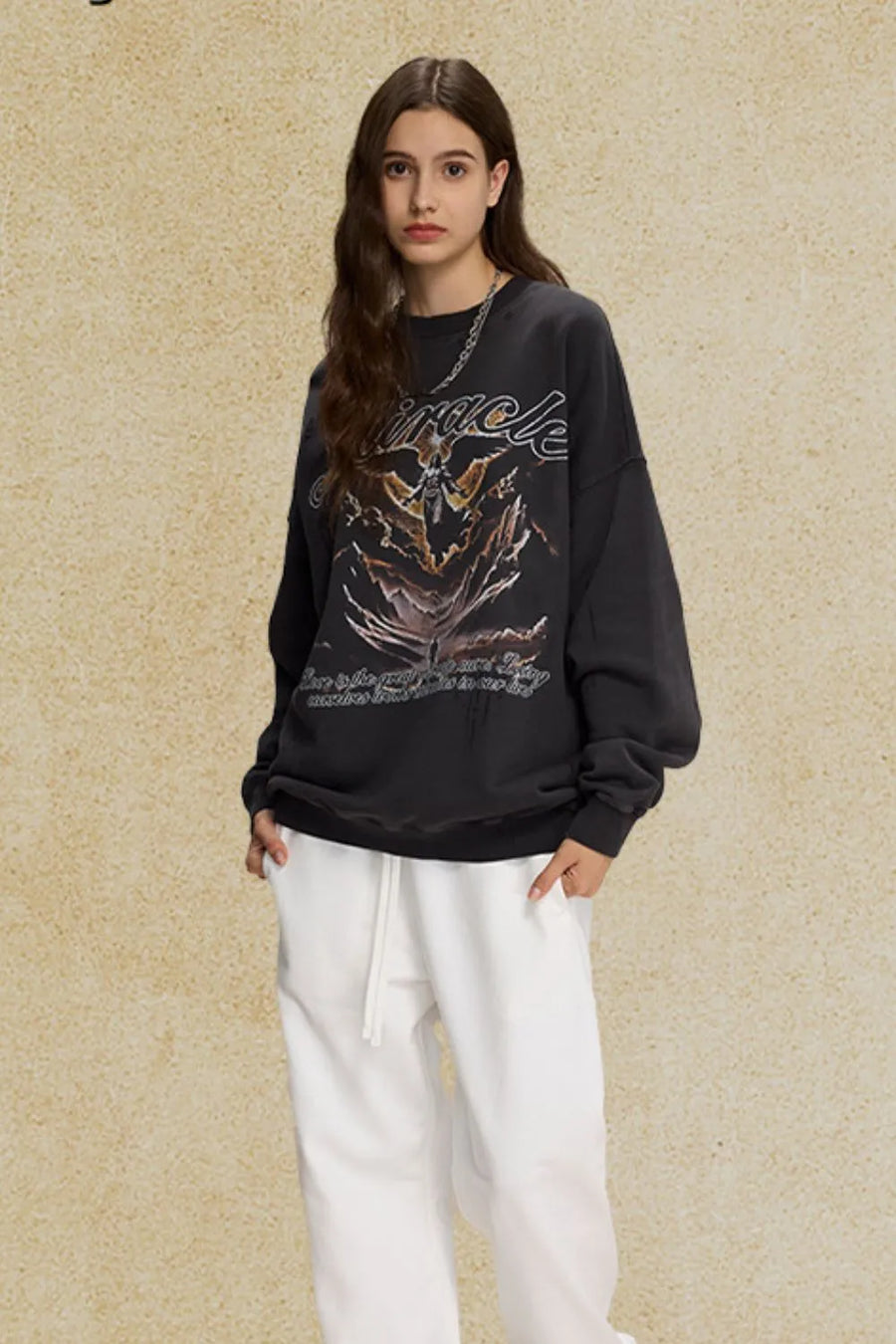 Black oversized sweatshirt with graphic print and text detail.