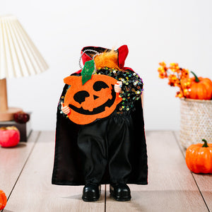 Halloween doll in black sequin top, black cape with red lining, holding a felt pumpkin.