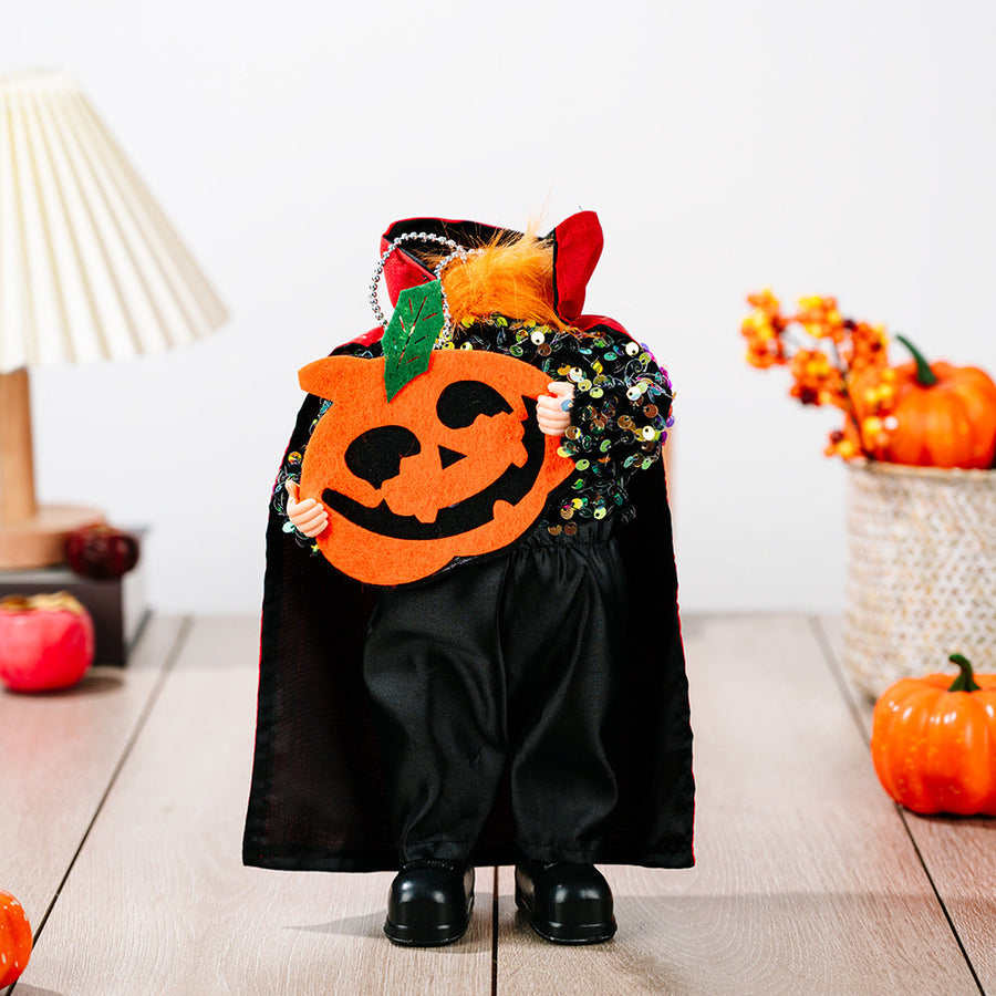 Halloween doll in black sequin top, black cape with red lining, holding a felt pumpkin.