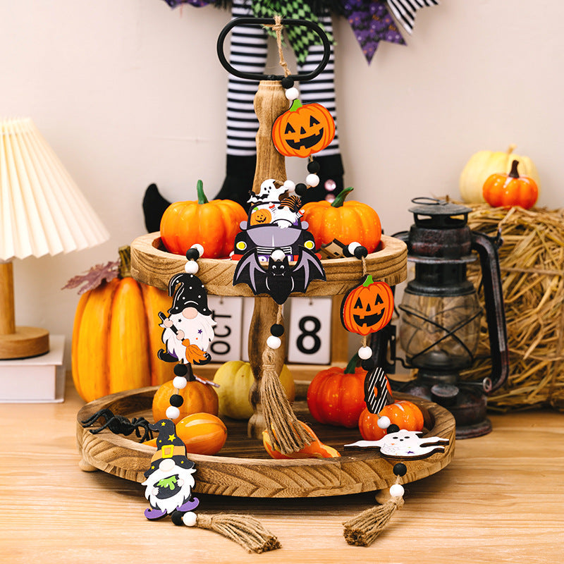 Halloween garland with pumpkins, gnomes, bats, and ghosts on a tiered tray.