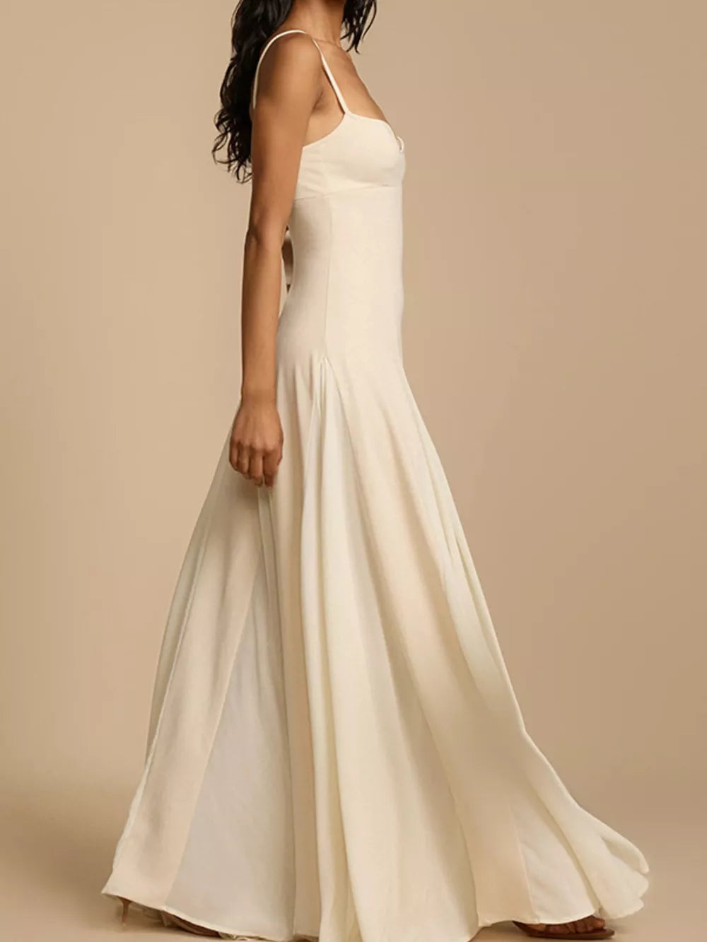 Elegant ivory sweetheart neck maxi dress with spaghetti straps and flowing skirt.