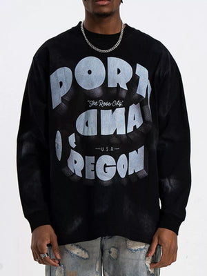 Black oversized long-sleeve t-shirt with bold "PORTLAND OREGON" graphic print.