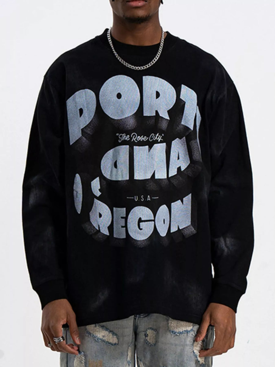 Black oversized long-sleeve t-shirt with bold "PORTLAND OREGON" graphic print.