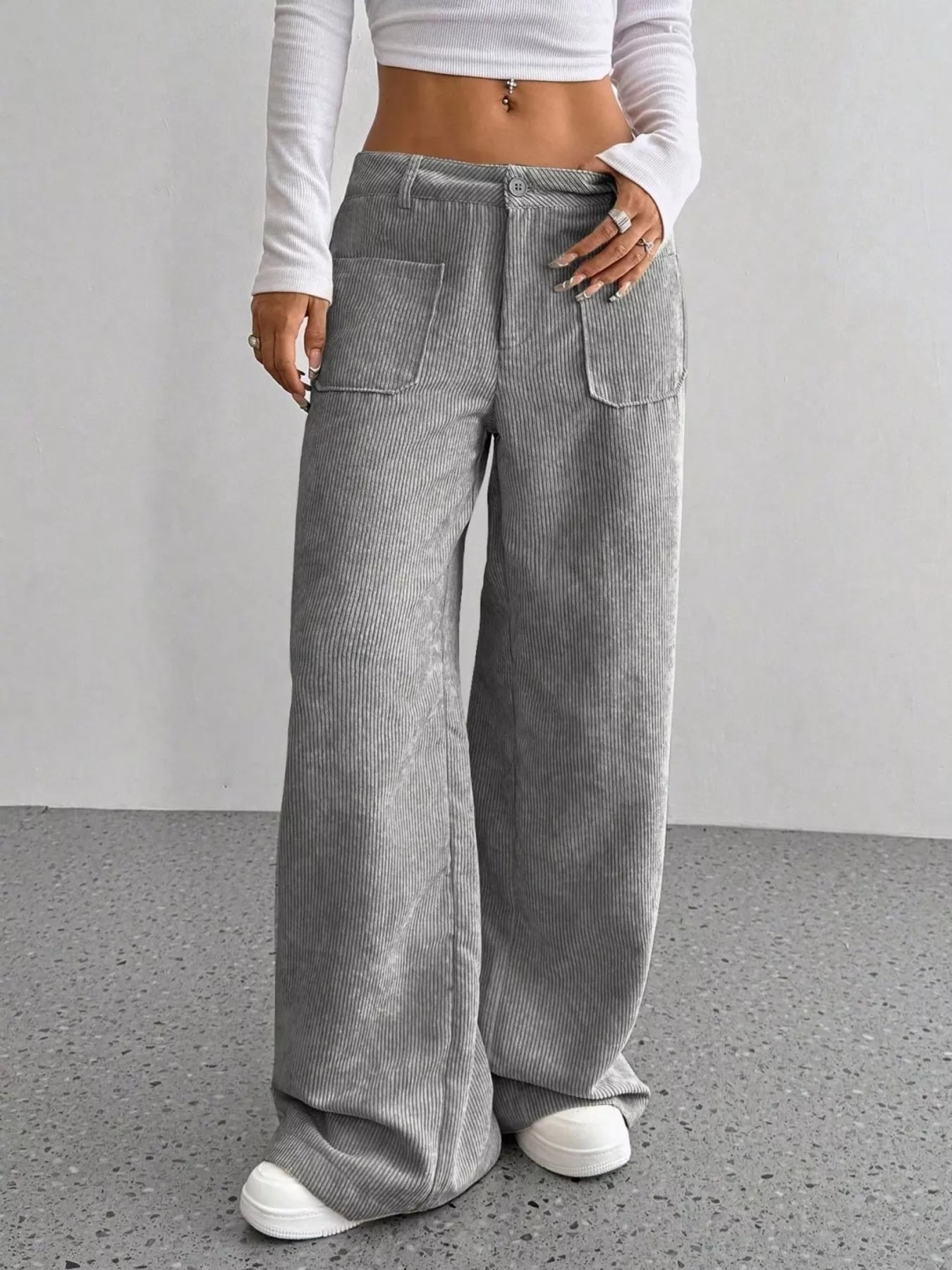 Grey corduroy wide-leg trousers with front pockets and a comfortable fit.