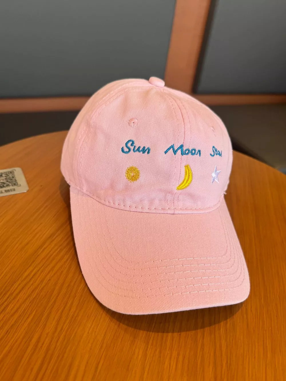 Blush pink cotton baseball cap with celestial embroidery and text.
