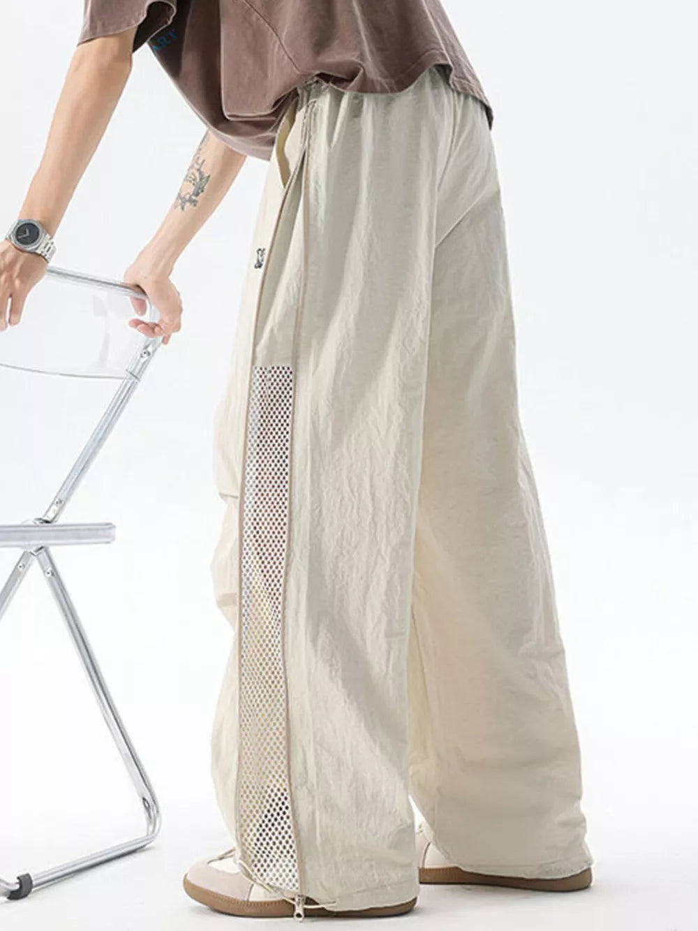 Cream cargo sweatpants with adjustable waist and mesh side detail.