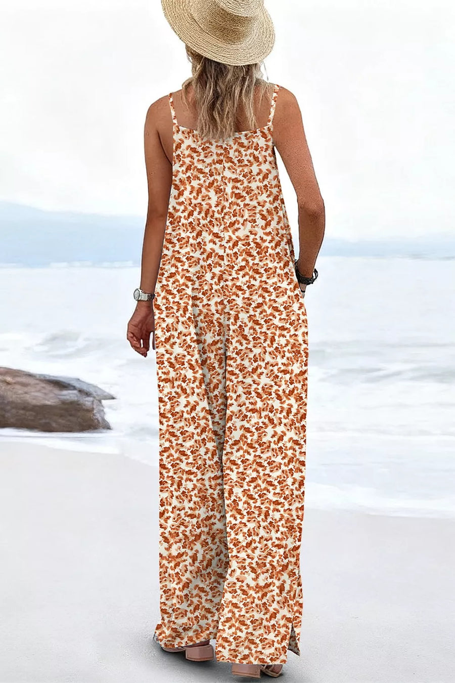Abstract floral wide-leg romper with pockets, spaghetti straps, and a square neckline.