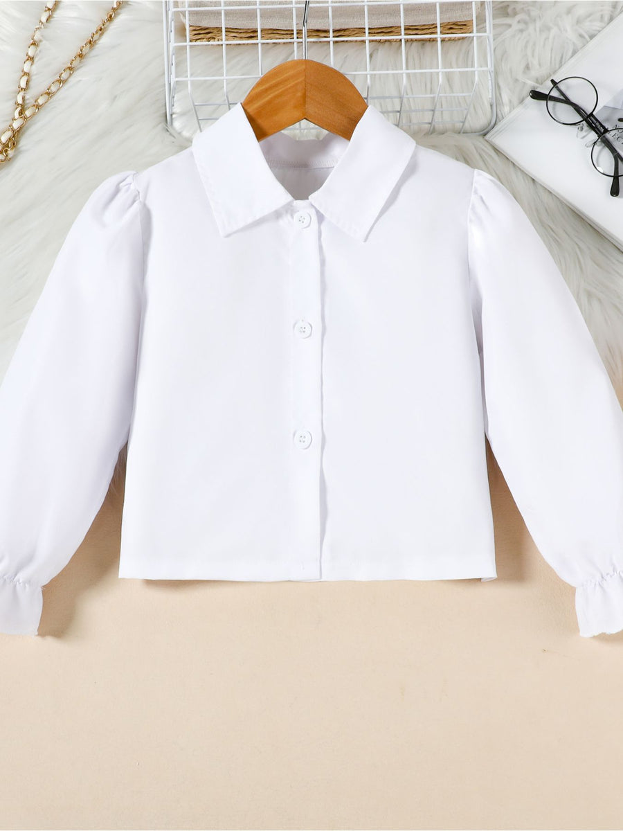 Toddler white collared long sleeve shirt with puff sleeves and ruffled cuffs.