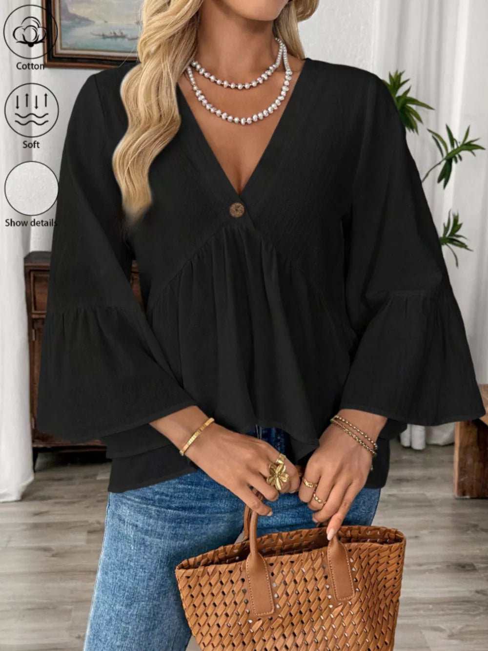 Black cotton V-neck blouse with bell sleeves and a button detail.