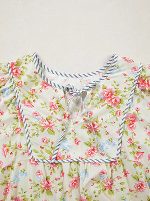 Floral cotton dress with puff sleeves and tie-neck detail, trimmed with gray stripes.
