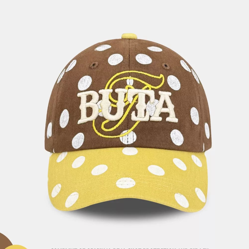 Brown polka dot baseball cap with yellow brim and embroidered BUTA logo
