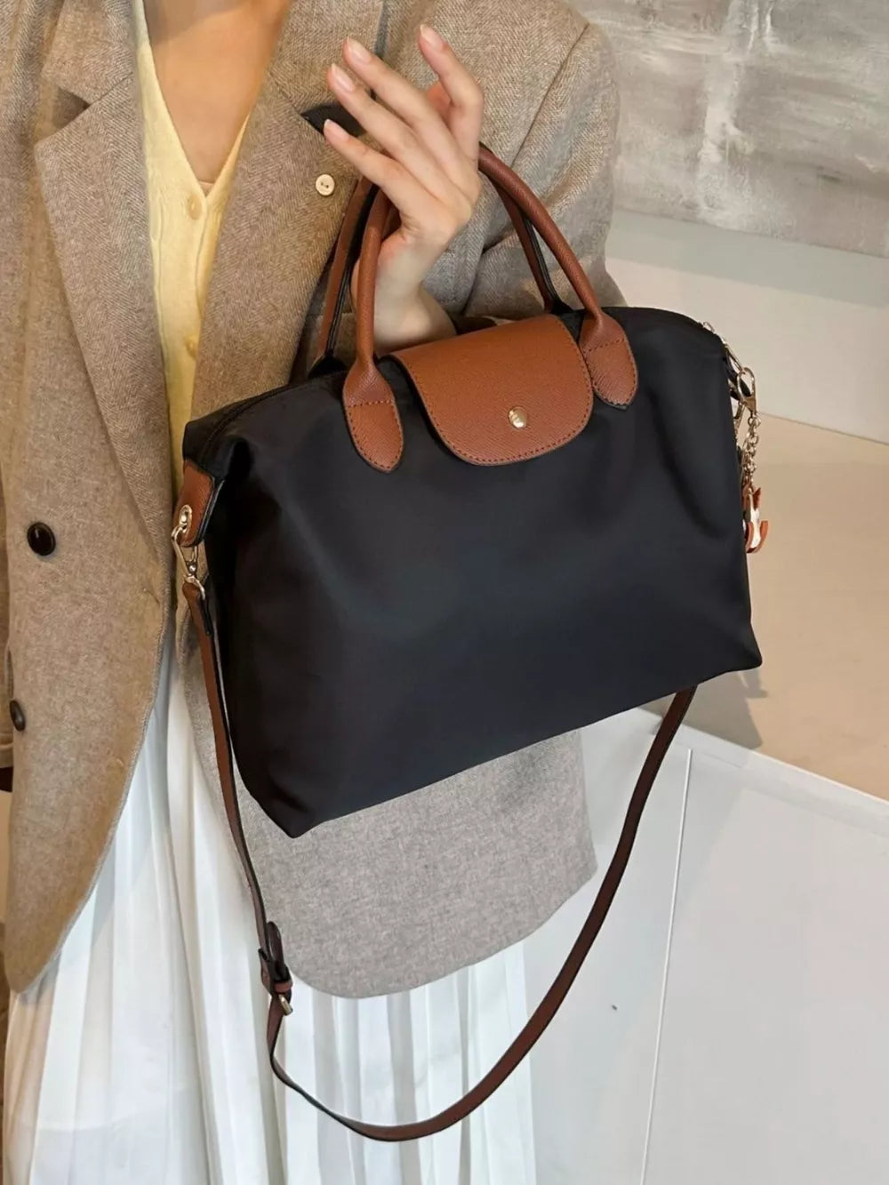 Black nylon tote bag with brown leather accents and strap