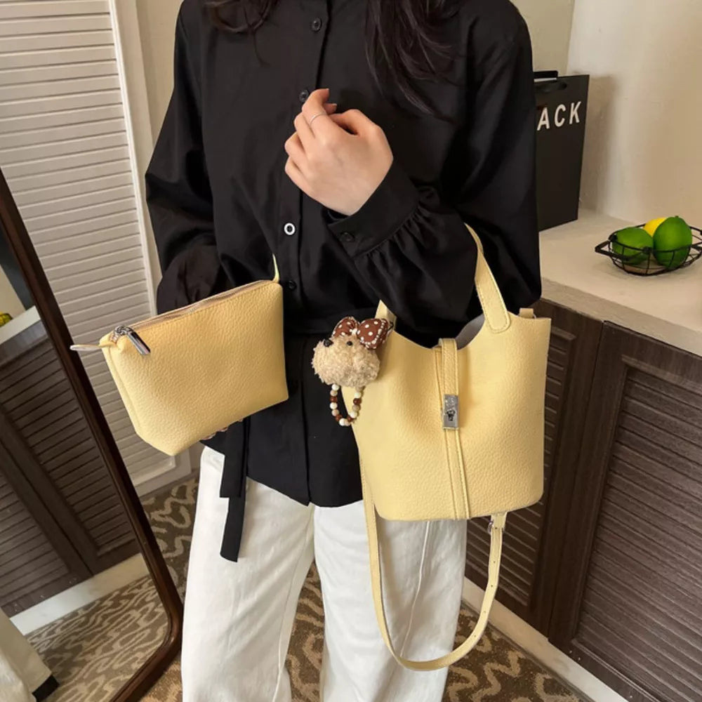 crossbody bag in pale yellow featuring adjustable strap and bucket fit
