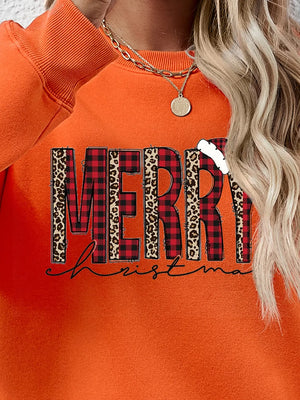 Orange graphic sweatshirt with "Merry Christmas" text in buffalo plaid and leopard print.