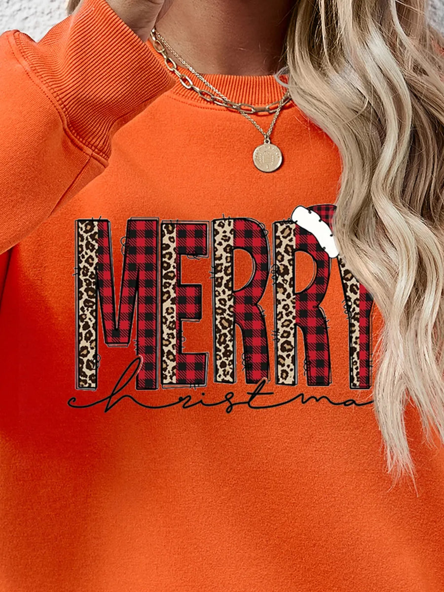 Orange graphic sweatshirt with "Merry Christmas" text in buffalo plaid and leopard print.