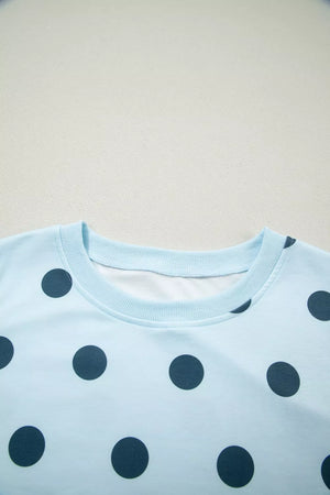Pastel blue polka dot crew neck top with ribbed collar and cuffs.