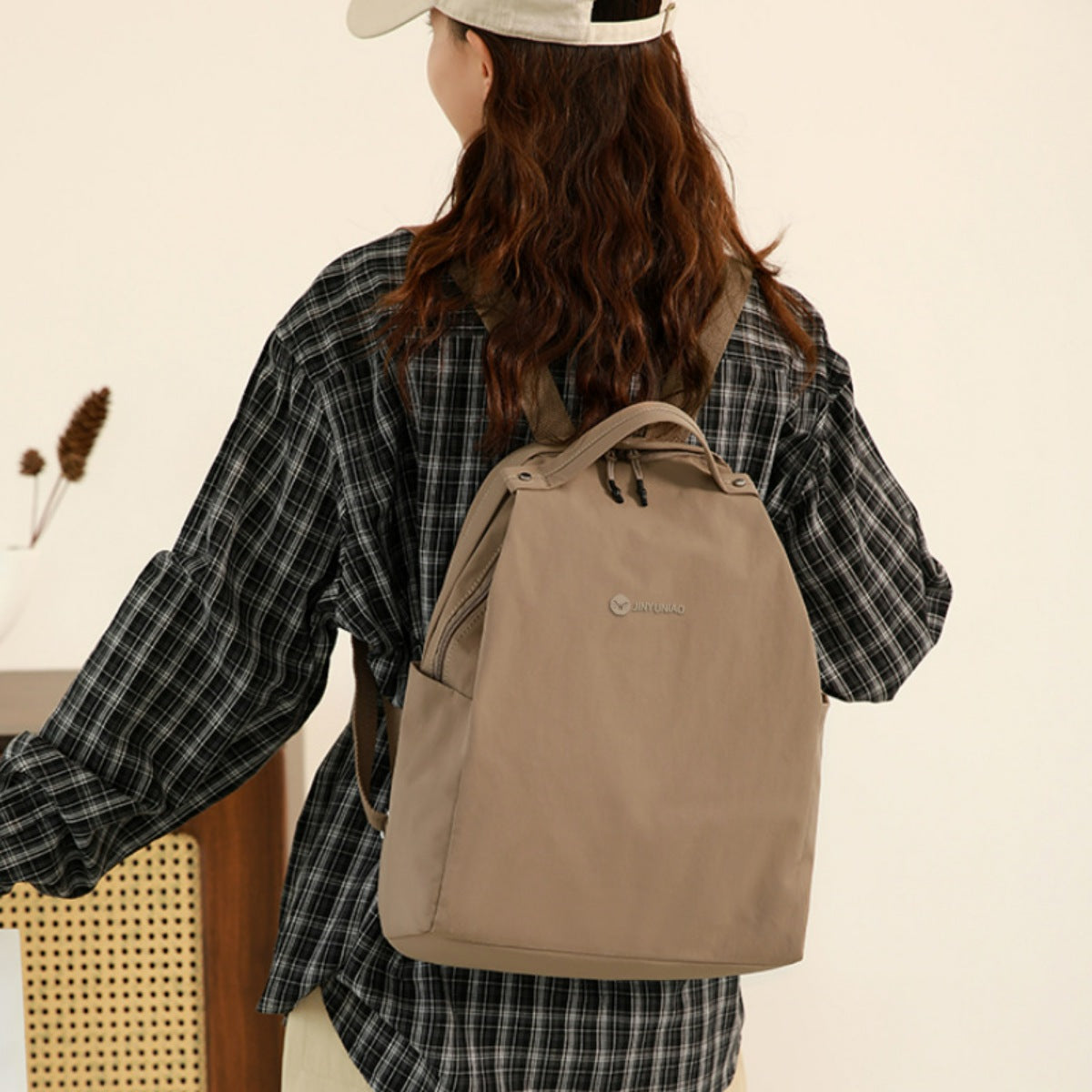 Medium nylon lightweight backpack in light brown with zippered main compartment and side pockets.