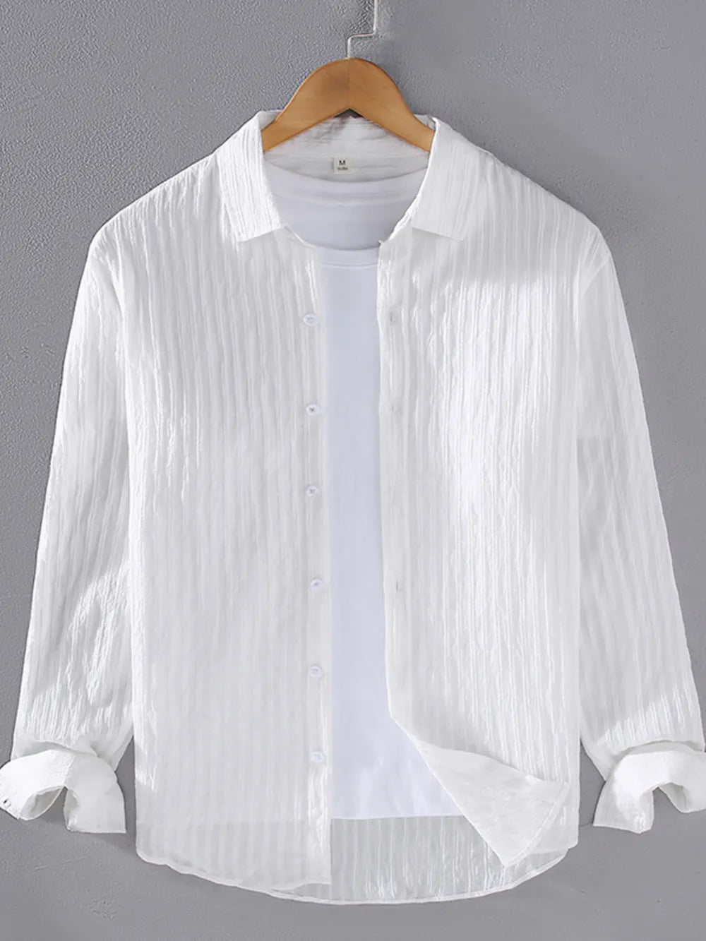 White textured long sleeve button-up overshirt with classic collar, worn over a white tee.