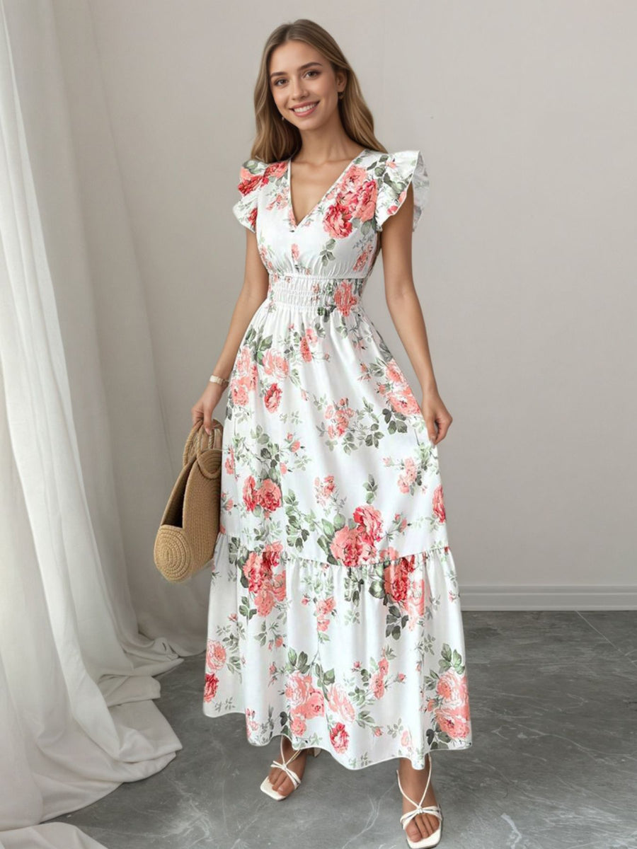 White floral maxi dress with ruffle sleeves, V-neck, and smocked waist.