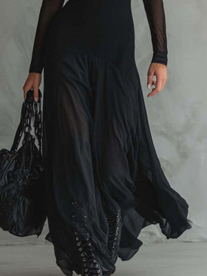 Black sheer mesh maxi dress with lace-up detail and flowing skirt, held by a model with a black bag.