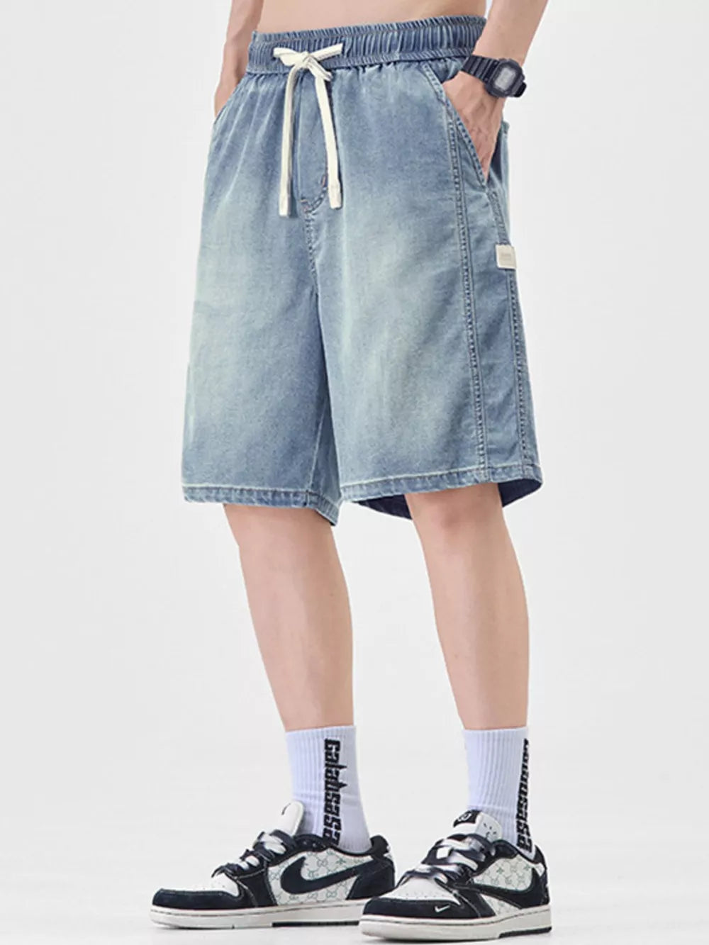 Light blue denim shorts for men with drawstring waist and loose fit.